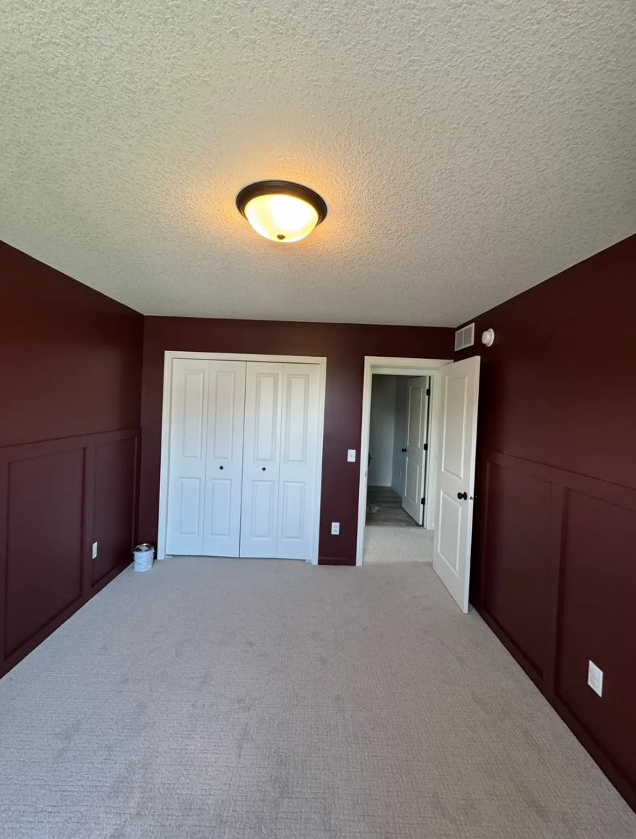 Interior bedroom painting — deep burgundy walls with wainscoting